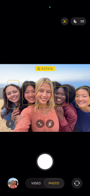 شاشة iPhone 17 Pro تعرض ميزة نمط 'في الوسط' للصور وكيفية التقاط صورة سيلفي لمجموعة من الأشخاص، مع إبراز وجوههم